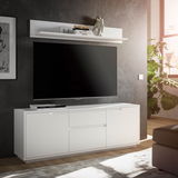 Modernes weißes TV-Lowboard mit Wandboard, frontal betrachtet, in einem stilvoll eingerichteten Wohnzimmer mit großem Fernseher und Dekoration.