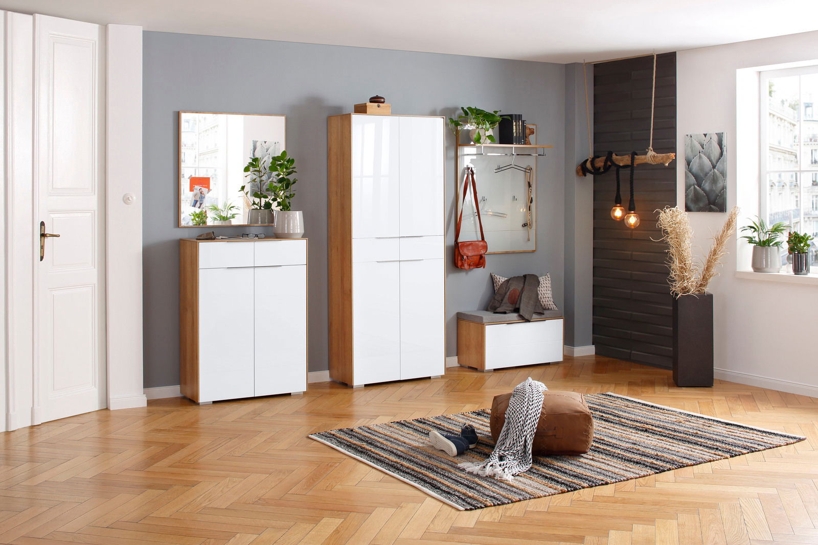 Moderne Garderobeneinrichtung mit Schuhschrank, Spiegel, Sitzbank und Garderobenpaneel in einem hellen Raum mit Holzboden, aus der Perspektive von vorne betrachtet.