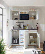 Moderne Single-Küche mit offenem Schrank, Mikrowelle, Spüle und Kühlschrank, aus der Frontalperspektive fotografiert.