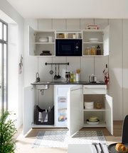 Moderne Single-Küche mit offenem Schrank, Mikrowelle, Spüle und Kühlschrank, aus der Frontalperspektive fotografiert.