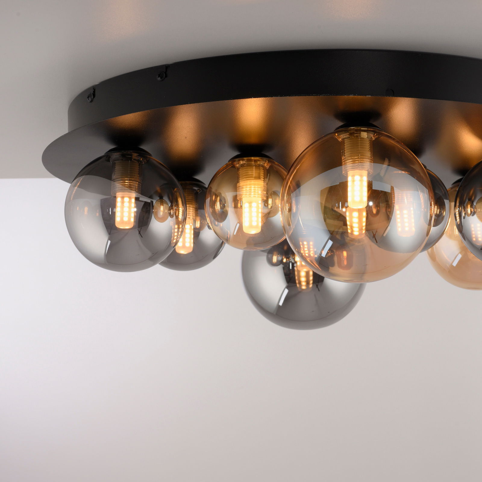Moderne LED-Deckenleuchte mit mehreren kugelförmigen Glühbirnen auf einer schwarzen Basis, seitliche Perspektive