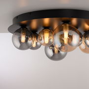 Moderne LED-Deckenleuchte mit mehreren kugelförmigen Glühbirnen auf einer schwarzen Basis, seitliche Perspektive