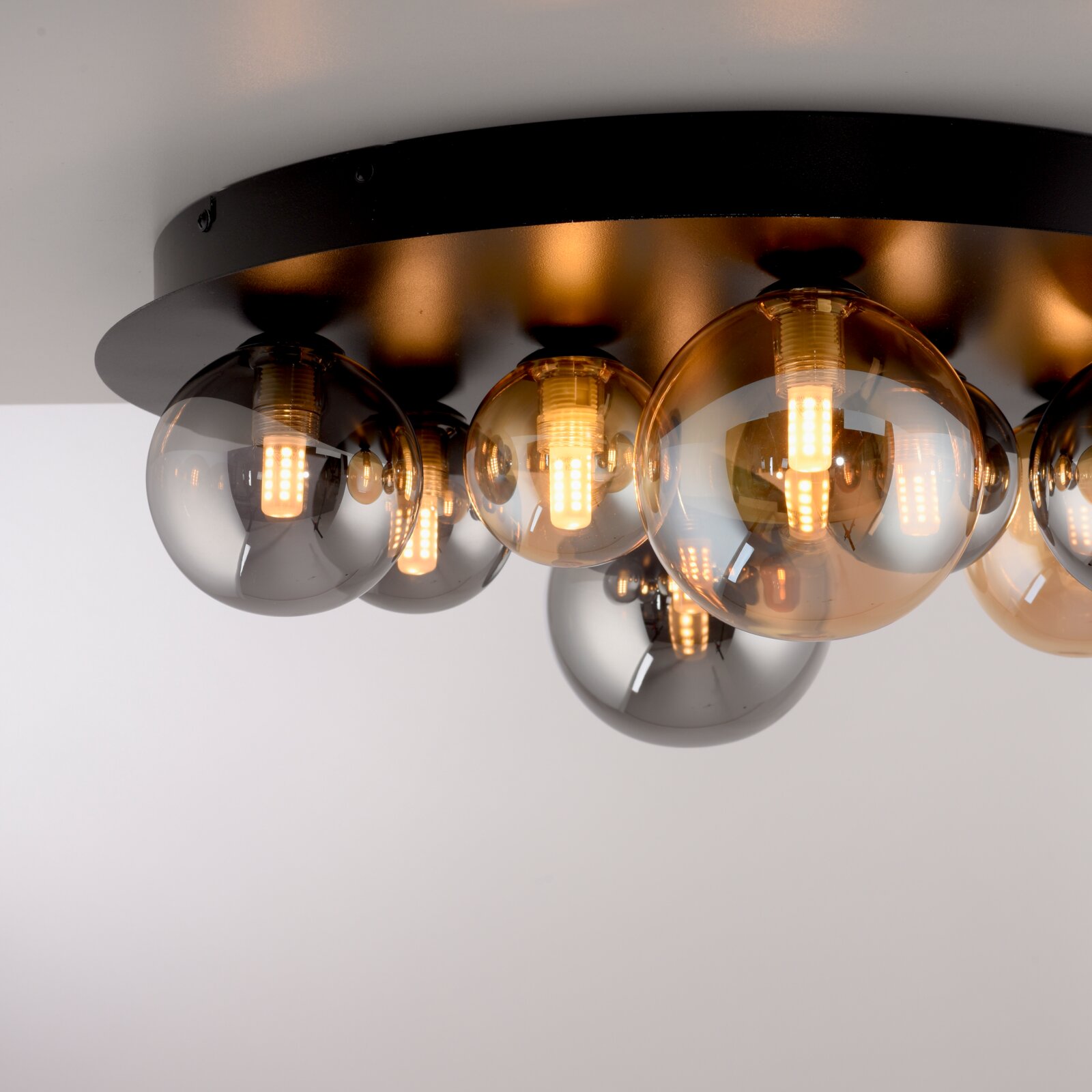 Moderne led-plafondlamp met meerdere bolvormige lampen op een zwarte voet, zijaanzicht