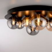 Moderne led-plafondlamp met meerdere bolvormige lampen op een zwarte voet, zijaanzicht