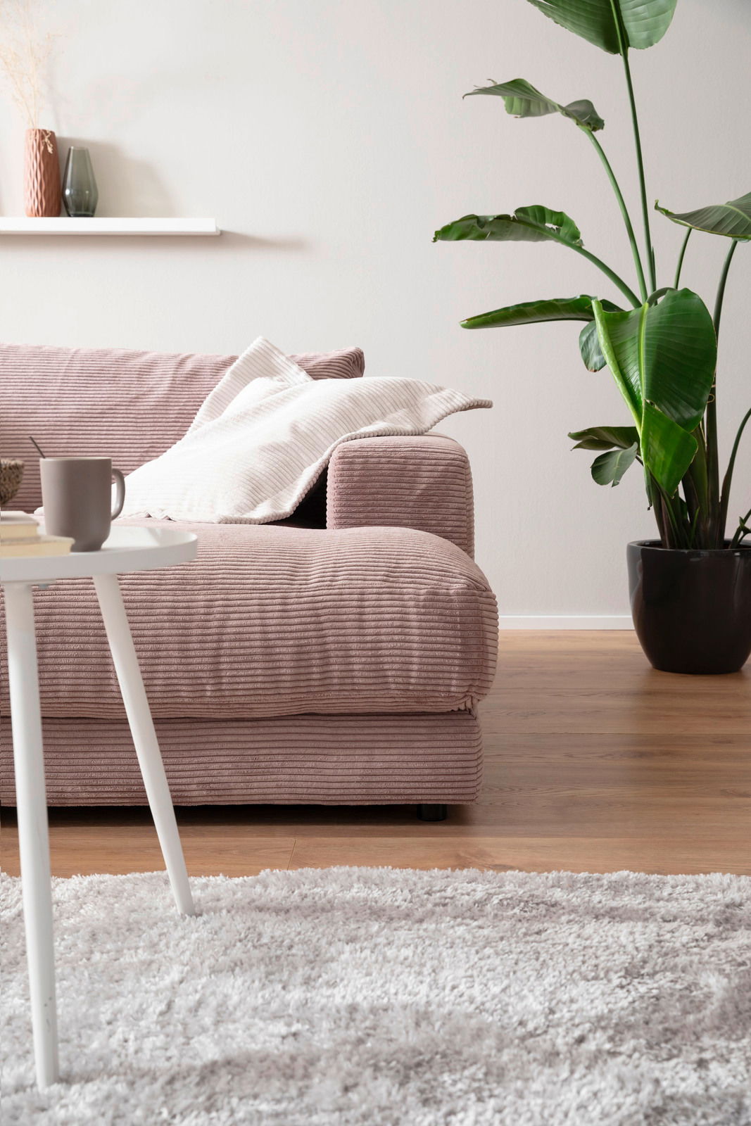 Gemütliches Megasofa in einem modernen Wohnzimmer, seitliche Perspektive, mit Kissen und einer Pflanze im Hintergrund.