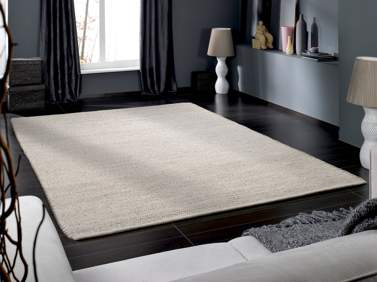 OCI Handweb Teppich FAVORIT Handgewebter Teppich in einem modernen Wohnzimmer, aus der Perspektive eines Sofas fotografiert.