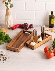 Längliches Servier-Tablett aus Holz, von oben fotografiert, umgeben von frischen Zutaten wie Tomaten, Paprika und Kräutern.