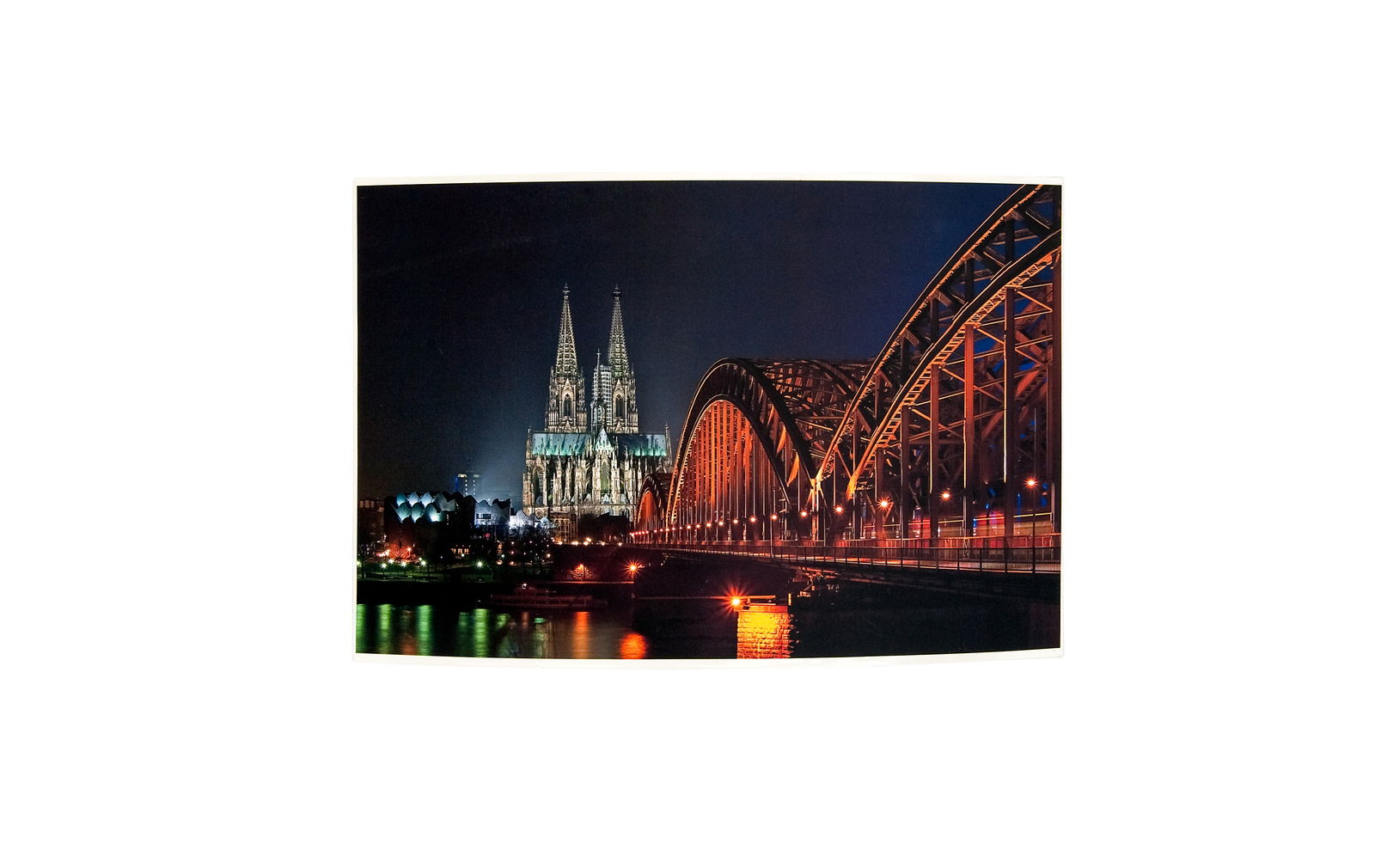 Nachtaufnahme des Kölner Doms und der Hohenzollernbrücke, seitliche Perspektive