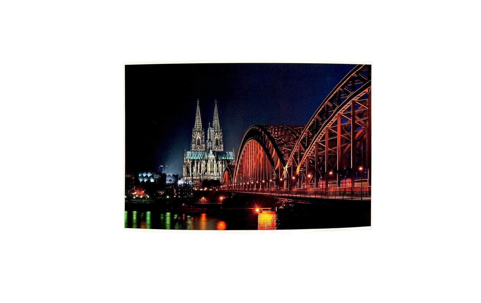 Nachtaufnahme des Kölner Doms und der Hohenzollernbrücke, seitliche Perspektive