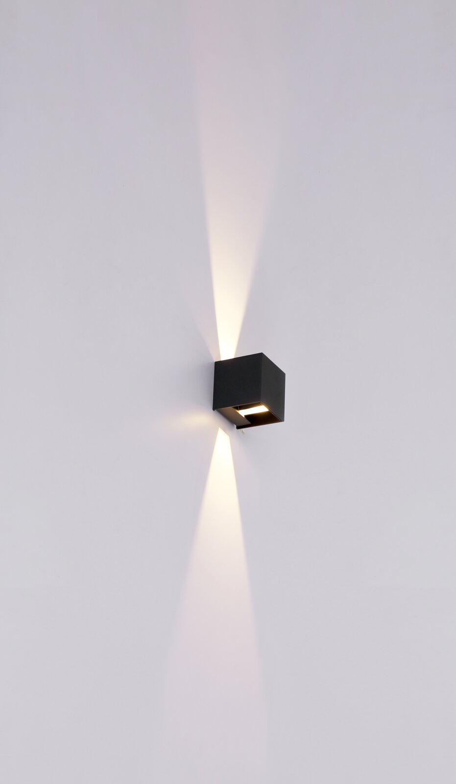 Moderne Außenleuchte in schwarzem Design, an der Wand montiert, mit nach oben und unten gerichteten Lichtstrahlen, seitliche Perspektive.