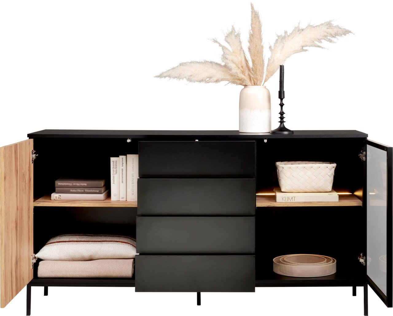 Modernes Sideboard mit schwarzer Front, offenen Türen und Schubladen, dekoriert mit Büchern, Körben und einer Vase mit Pampasgras, frontal betrachtet.