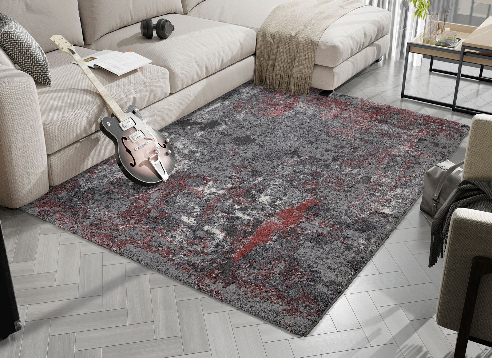 OCI Designer Teppich JUWEL Designer Teppich in Grau- und Rottönen, platziert in einem modernen Wohnzimmer mit Sofa und Gitarre, aus der Vogelperspektive betrachtet.