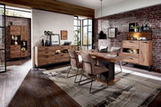 Moderne Esszimmer-Einrichtung mit Holzmöbeln, bestehend aus einem Esstisch, Sideboard und Vitrine, in einem Raum mit Backsteinwand und großen Fenstern. Perspektive von vorne.
