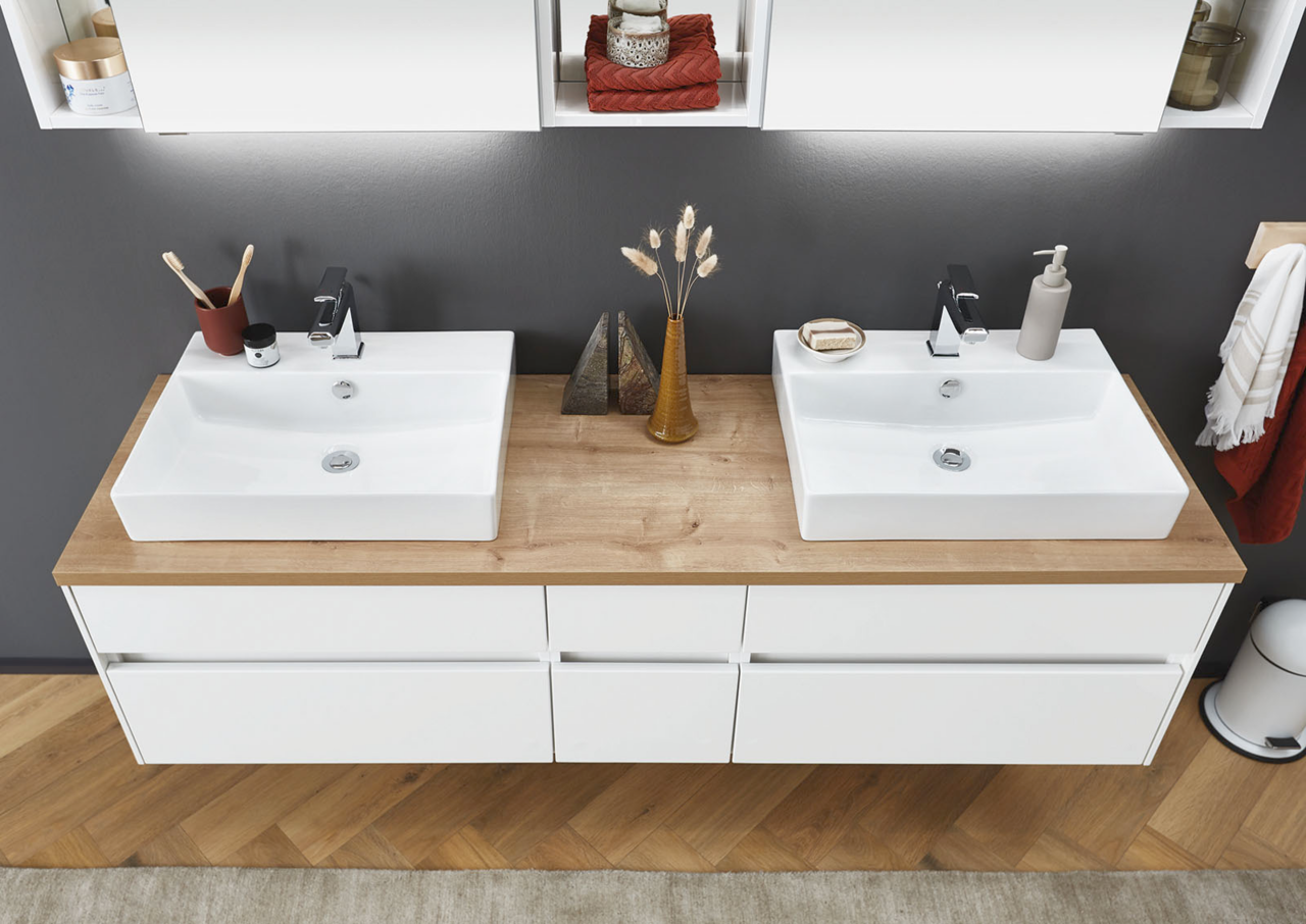 Novel Metalluntergestell 45 MALIN Weißer Schrank mit drei Schubladen auf Metalluntergestell, frontal fotografiert. Dekoriert mit Vasen und einer Tasse auf der Oberseite.