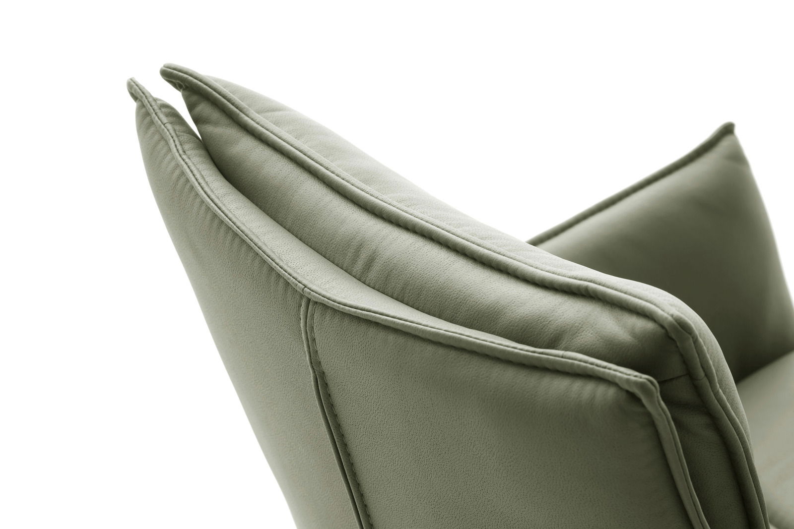 Nahaufnahme eines grünen Sessels von der Seite, die Polsterung und Nähte sind deutlich sichtbar.