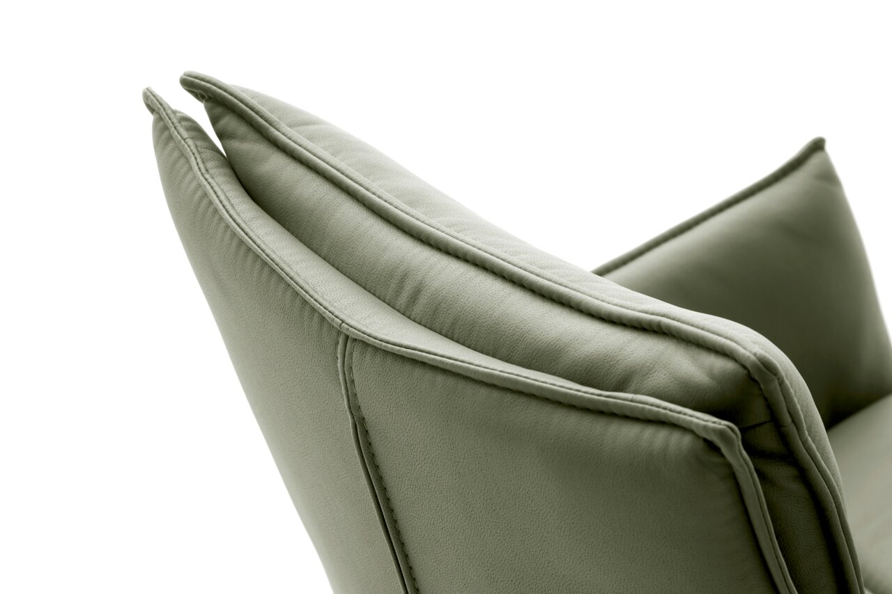Nahaufnahme eines grünen Sessels von der Seite, die Polsterung und Nähte sind deutlich sichtbar.