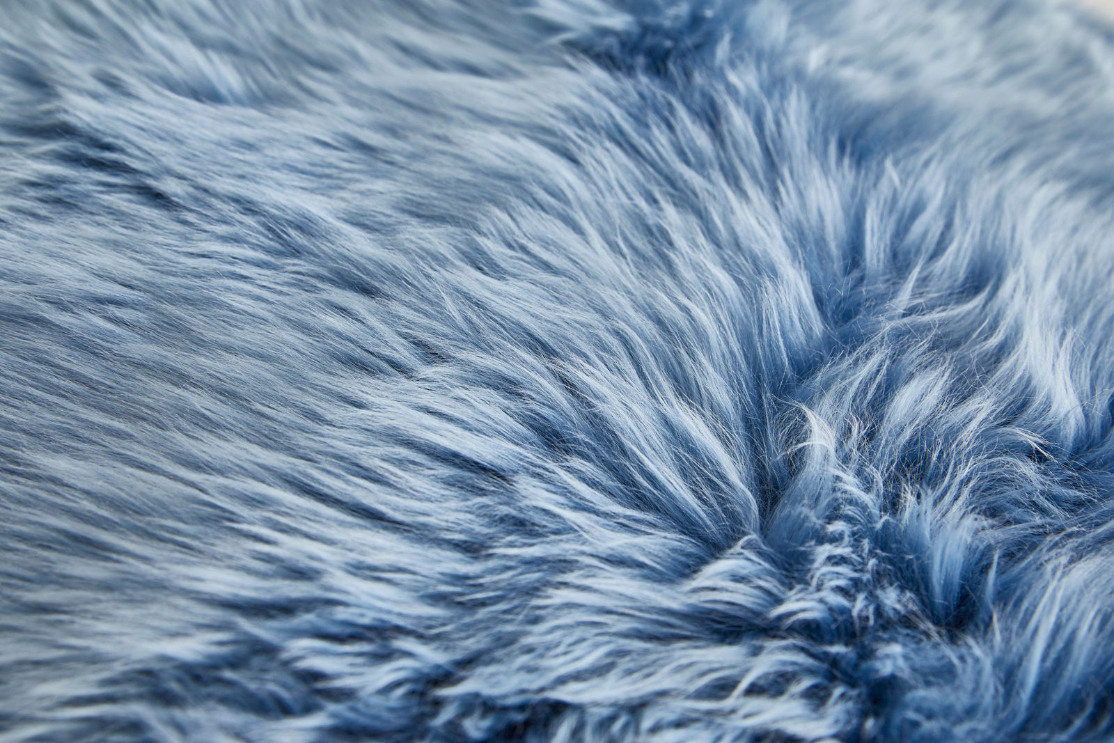 Nahaufnahme eines blauen Schaffells mit weicher, flauschiger Textur.