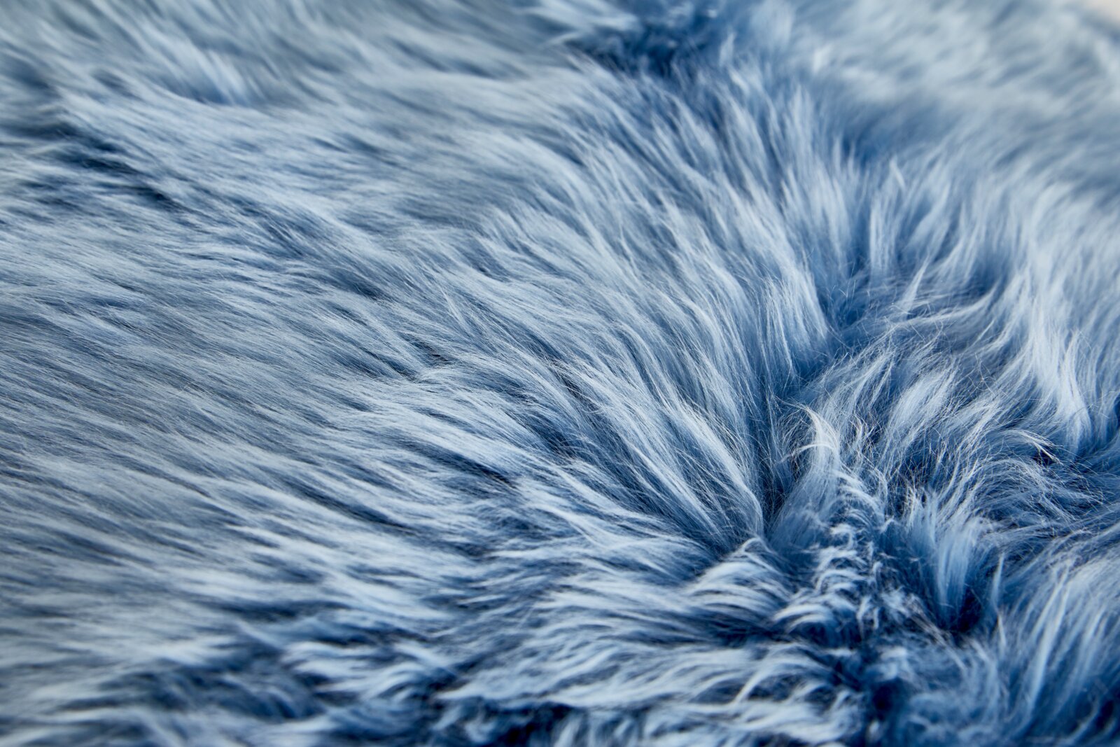 Close-up van een blauwe schapenvacht met een zachte, donzige textuur.