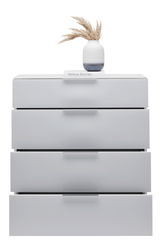 Weiße Schubkastenkommode mit vier Schubladen, darauf eine Vase mit getrockneten Gräsern und ein Buch, frontale Perspektive.