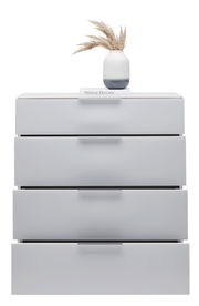 Weiße Schubkastenkommode mit vier Schubladen, darauf eine Vase mit getrockneten Gräsern und ein Buch, frontale Perspektive.