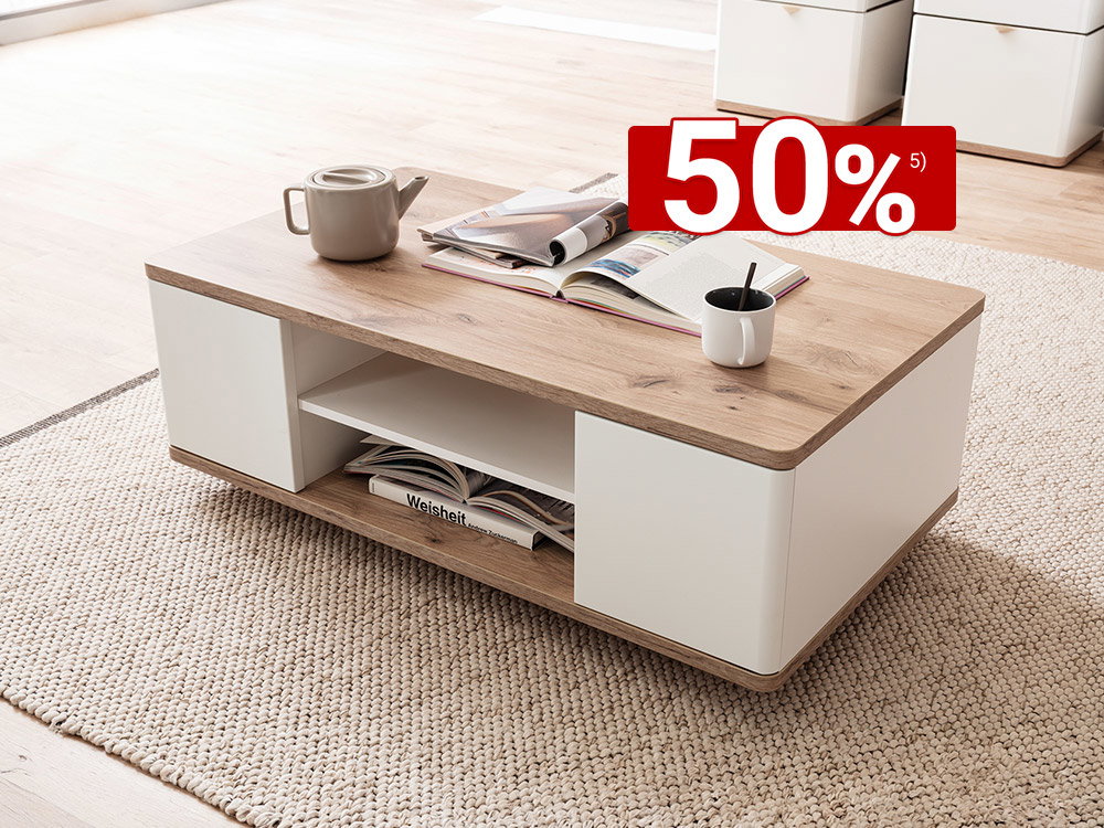 Moderner Couchtisch in Holzoptik mit weißen Elementen, Deko und Tasse auf hellem Teppich im Wohnzimmer.