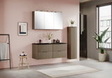 Moderner Midischrank in Holzoptik, hängend an einer rosa Wand, mit Pflanzen und Dekorationen, seitliche Perspektive.