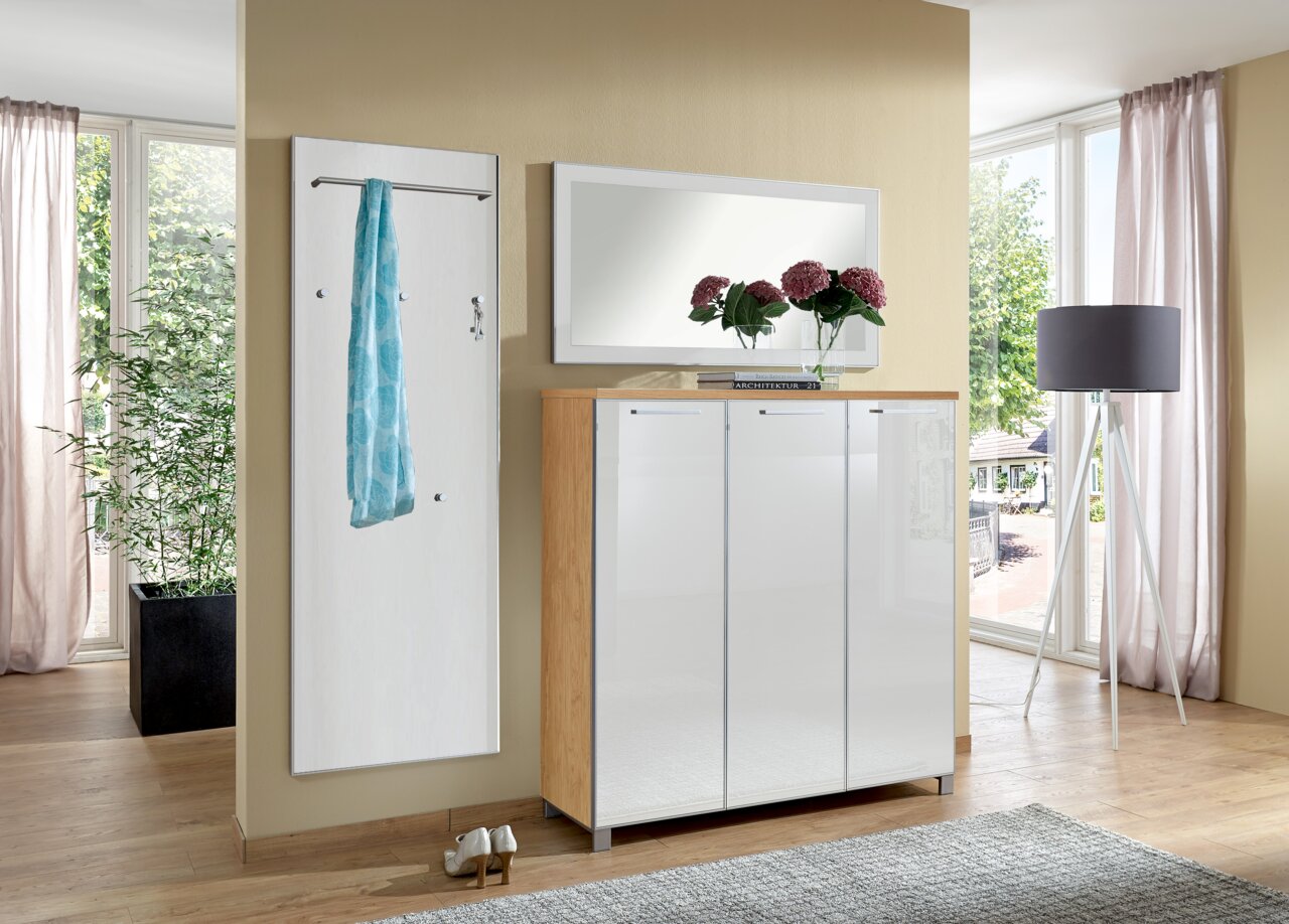 VOSS Garderoben-Set 3-tlg. (Set55) SANTINA Garderoben-Set bestehend aus einem weißen Wandpaneel mit Kleiderstange und Haken, einem großen Spiegel und einem weißen Schrank mit Holzrahmen, in einem modernen, hellen Raum mit großen Fenstern, aus frontaler Perspektive.