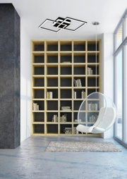 Moderne LED-Deckenleuchte in geometrischem Design, an der Decke eines stilvollen Wohnzimmers mit Bücherregal und Hängesessel montiert, aus der Perspektive des Raumes betrachtet.
