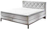 Boxspringbett in seitlicher Perspektive mit gepolstertem Kopfteil und eleganter Steppung