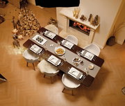 Eleganter Esstisch mit festlichem Gedeck aus der Vogelperspektive, dekoriert mit dem Tafelbesteck 30-teilig NewWave, umgeben von stilvoller Weihnachtsdekoration und einem Kamin im Hintergrund.