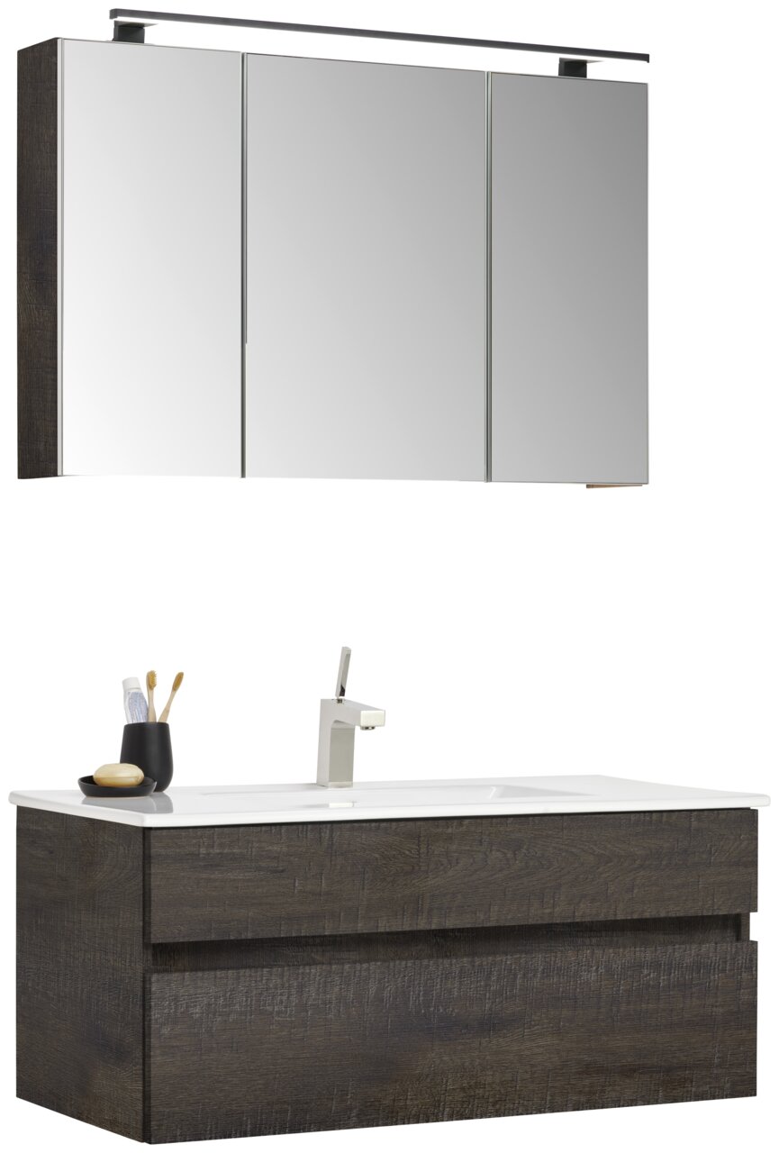 Badezimmermöbel-Set mit dunklem Holzfinish, bestehend aus einem Spiegelschrank mit drei Türen und einem Waschtisch mit integriertem Waschbecken und moderner Armatur, seitliche Perspektive