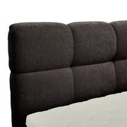 Nahaufnahme eines gepolsterten, dunkelgrauen Boxbett-Kopfteil mit sichtbarer Matratze in Seitenansicht.