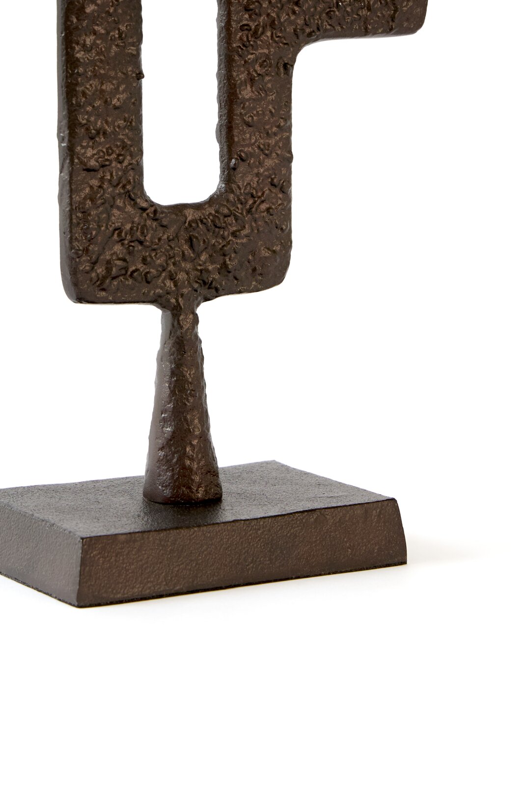 Close-up vanuit licht schuin vooraanzicht van een donkerbruin abstract metalen sculptuur met reliëfstructuur op een rechthoekige sokkel tegen een witte achtergrond.