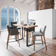 Moderner Bartisch mit Holzplatte und schwarzen Metallbeinen, umgeben von stilvollen Barhockern in einem hellen Raum mit Blick auf einen See. Perspektive: seitlich.