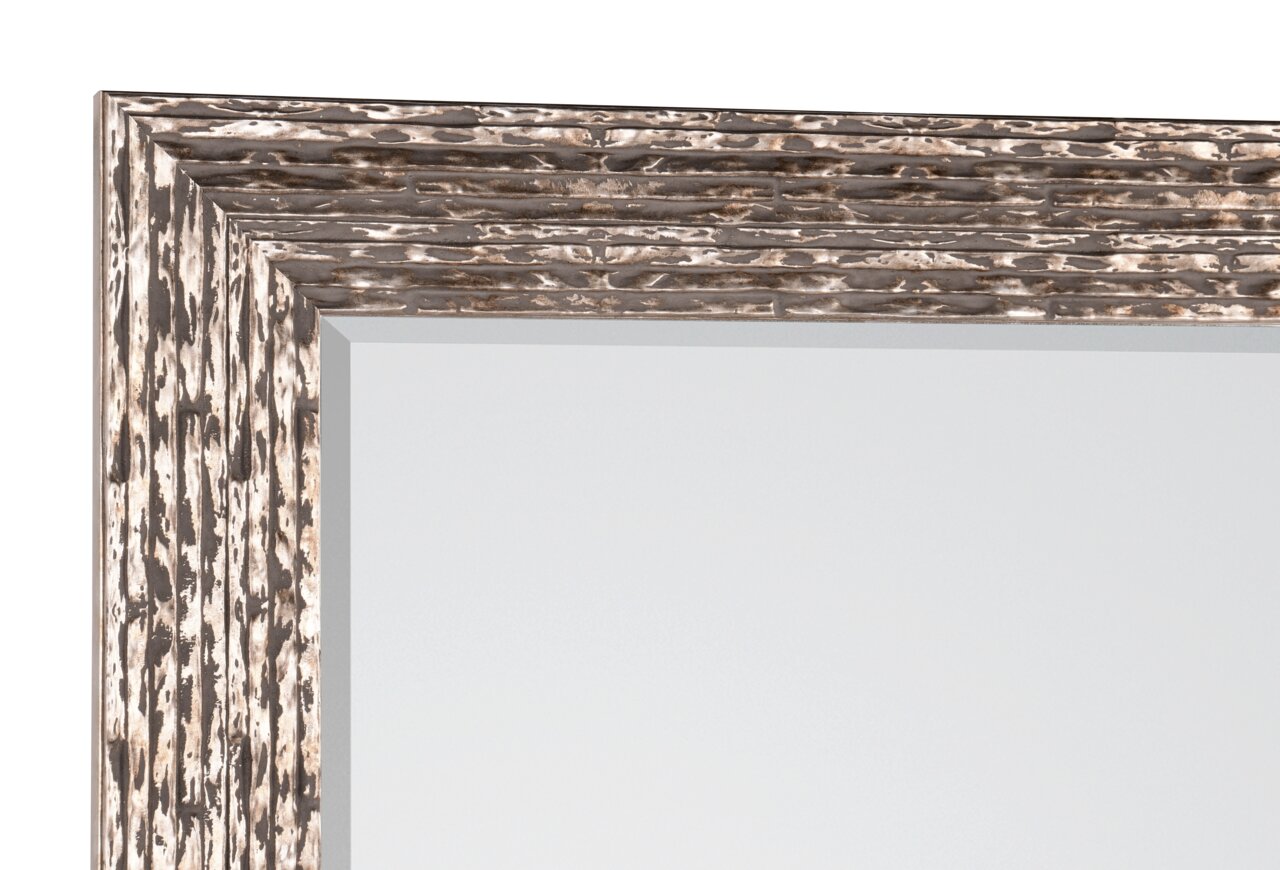 Nahaufnahme eines Spiegels mit einem dekorativen, strukturierten Rahmen in Holzoptik, Perspektive von der Ecke.