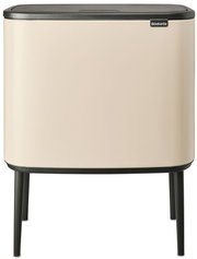 Moderner cremefarbener Abfalleimer mit schwarzem Deckel und Beinen, Frontalansicht