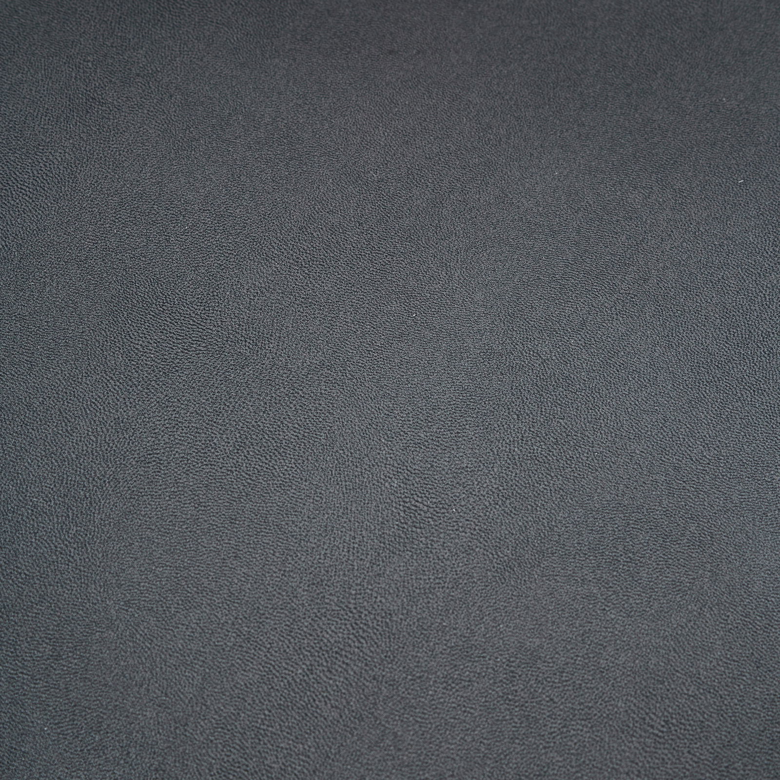Nahaufnahme einer dunkelgrauen, strukturierten Oberfläche eines Stuhlsitzes
