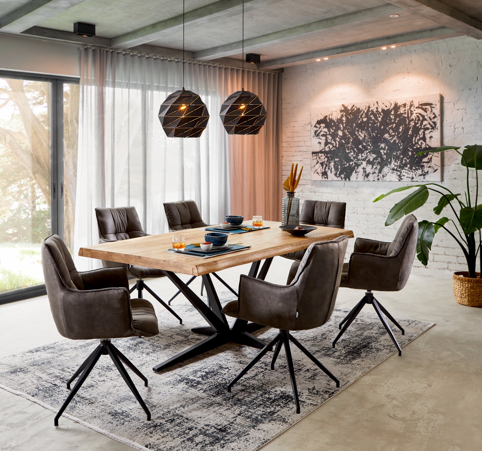 Moderner Esstisch mit Holzplatte und schwarzen Metallbeinen, umgeben von sechs gepolsterten Stühlen in einem stilvollen Esszimmer mit großen Fenstern und dekorativen Hängeleuchten. Perspektive: seitliche Ansicht.