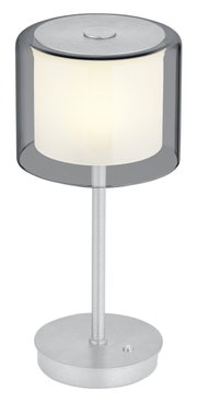 Moderne LED-Tischleuchte KLARA mit zylindrischem, transparentem Schirm und silbernem Standfuß, seitliche Perspektive.