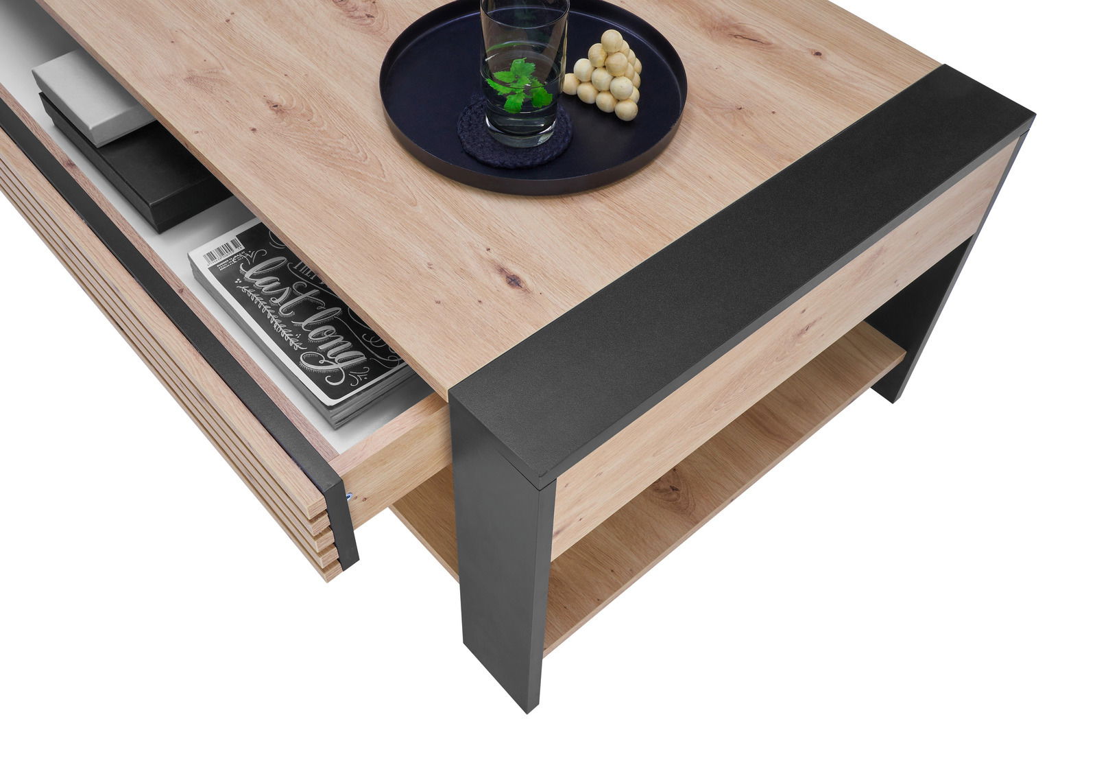 Moderner Couchtisch aus Holz mit schwarzem Metallrahmen, seitliche Perspektive, zeigt eine Schublade mit Büchern und ein Tablett mit Glas und Snacks auf der Tischplatte.