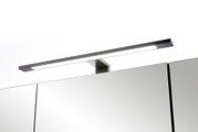 Schlanke LED-Spiegelleuchte in gebürsteter Edelstahl-Optik auf einem Badezimmerspiegelschrank, schräg von vorne oben fotografiert