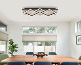 Moderne LED-Deckenleuchte in geometrischem Design, montiert an der Decke eines Esszimmers, aus der Perspektive des Raumes betrachtet.