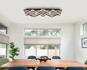 Moderne LED-Deckenleuchte in geometrischem Design, montiert an der Decke eines Esszimmers, aus der Perspektive des Raumes betrachtet.