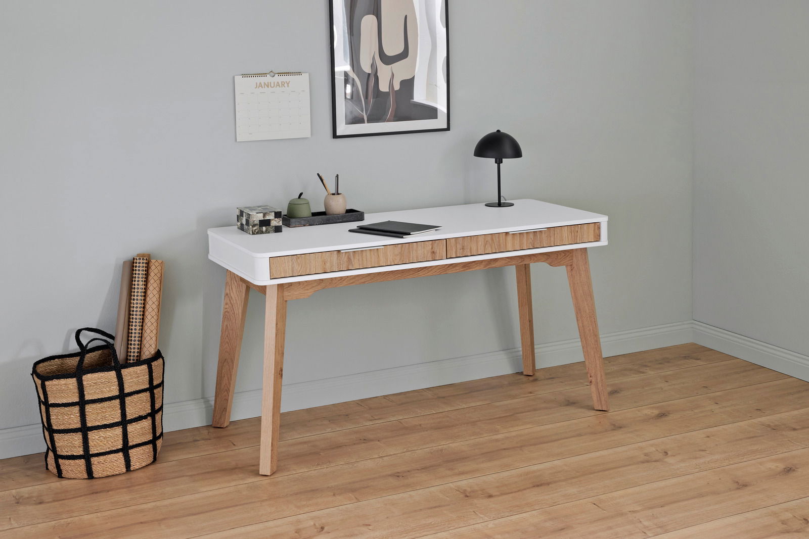 Moderner Schreibtisch aus Holz mit weißer Tischplatte, seitlicher Perspektive, dekoriert mit Lampe, Notizbuch und Stiftehalter.