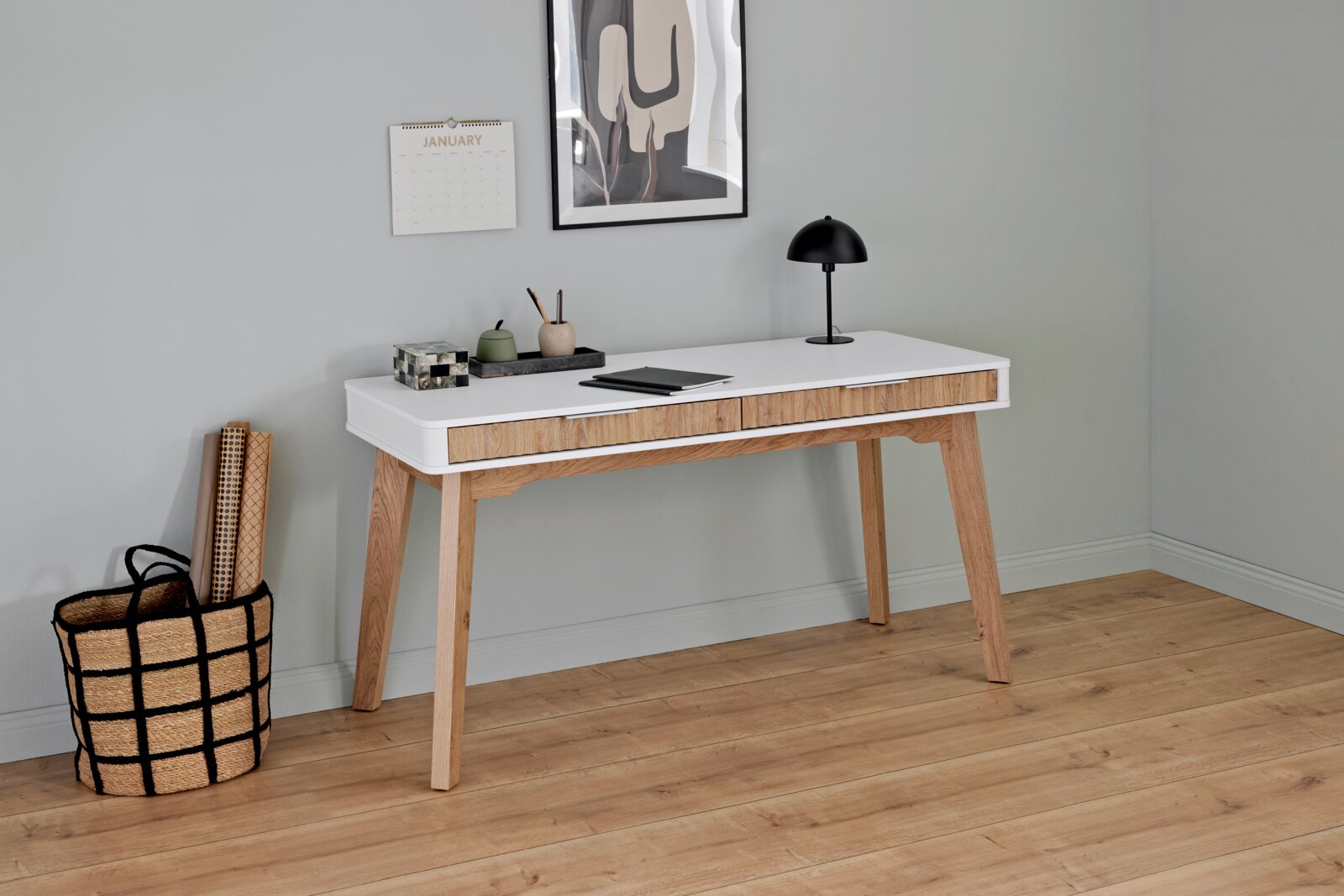 Novel Bureau WAVE Moderner Schreibtisch aus Holz mit weißer Tischplatte, seitlicher Perspektive, dekoriert mit Lampe, Notizbuch und Stiftehalter.