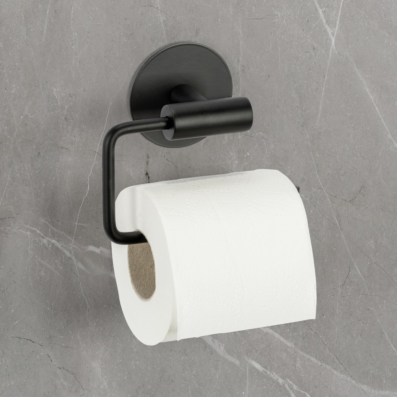 Schwarzer Toilettenpapierhalter Meleto an einer grauen Wand, seitliche Perspektive