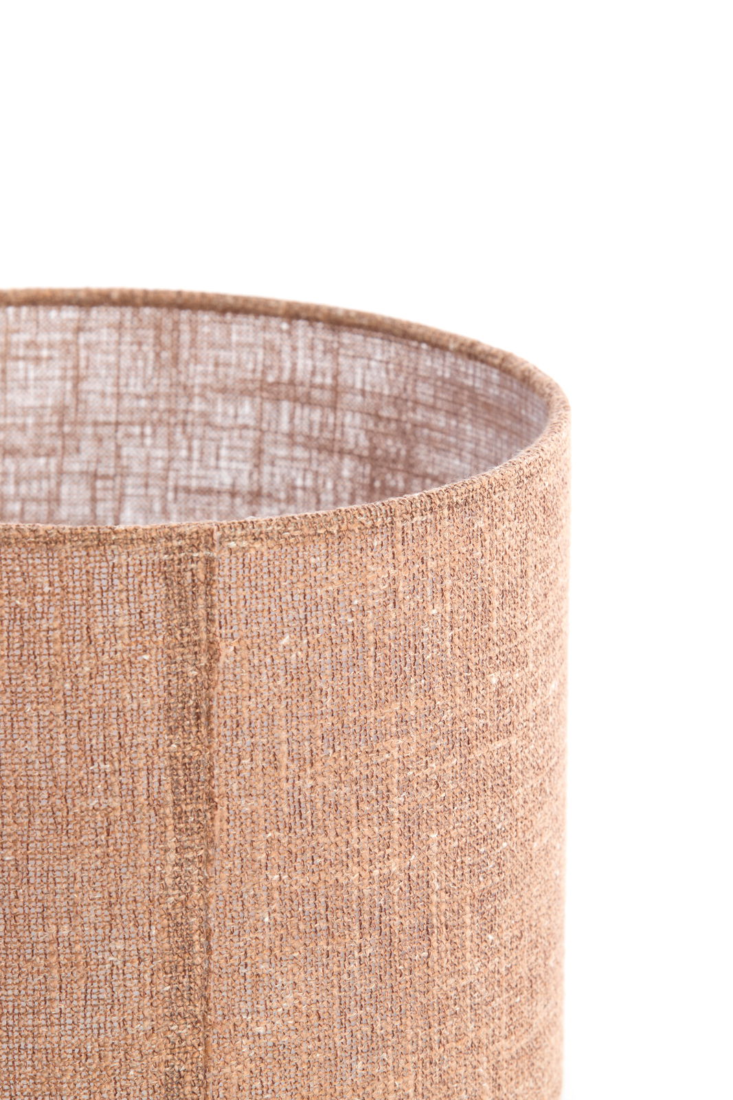 Nahaufnahme eines zylindrischen, beige-braunen Lampenschirms aus strukturiertem Stoff, von der Seite betrachtet.