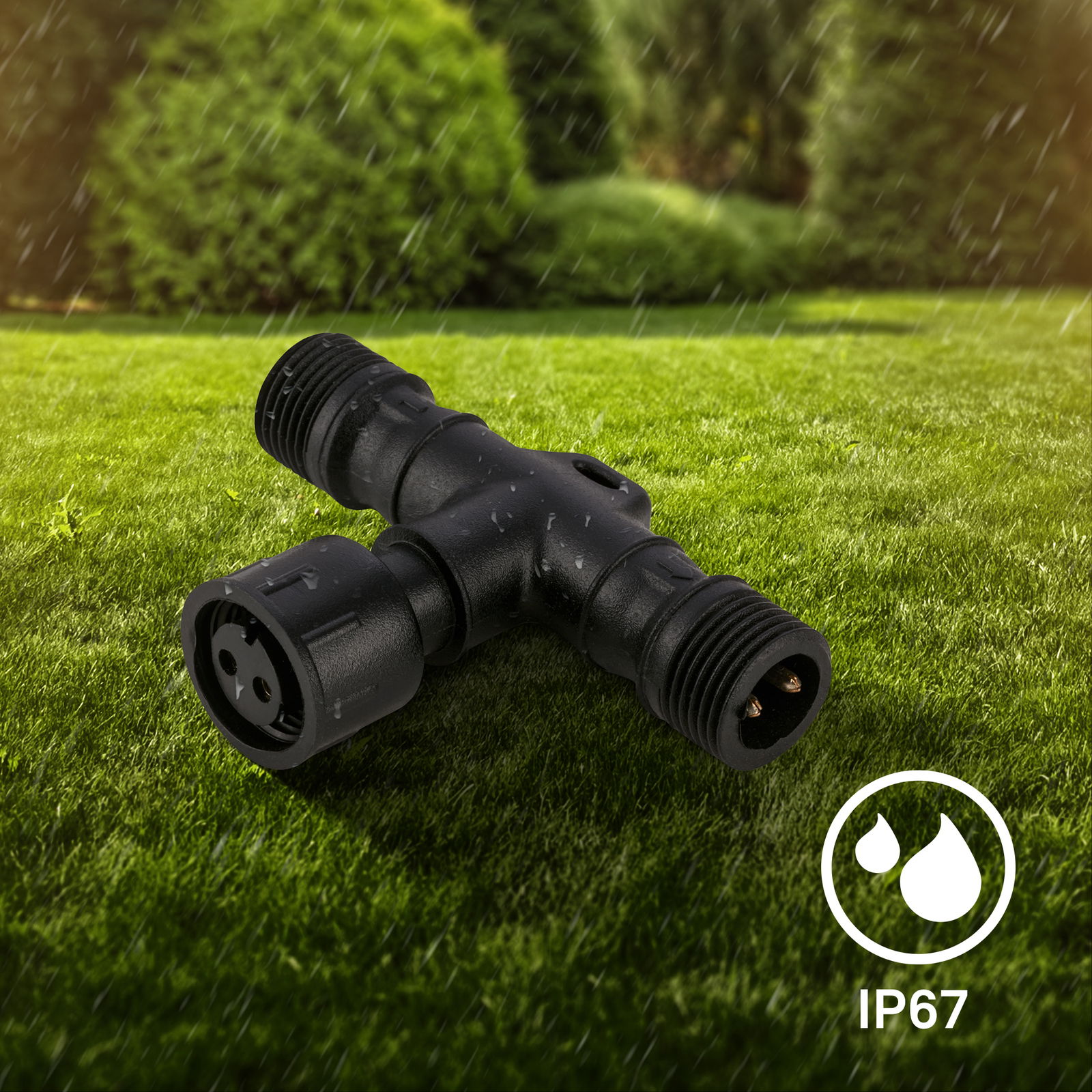 Schwarzer T-Verbinder auf einer Wiese, IP67 zertifiziert, in einer leicht seitlichen Perspektive.