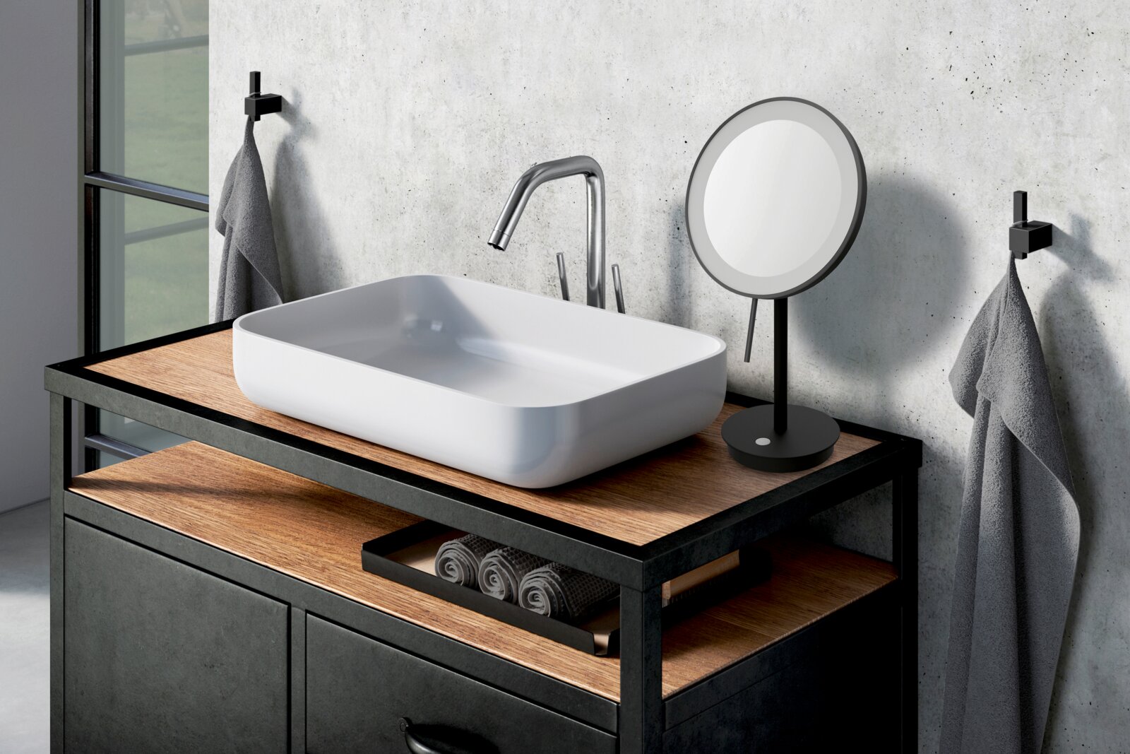 Modernes Badezimmer-Waschbecken aus weißer Keramik als Aufsatzbecken auf Holzplatte mit schwarzem Metallrahmen, hoher Chrom-Armatur und rundem Schminkspiegel Perspektive: leicht erhöhte Frontansicht von schräg links.