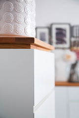 Nahaufnahme eines weißen Möbelstücks mit Holzplatte, seitliche Perspektive